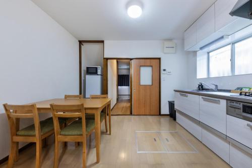 a kitchen with a table and chairs in a room at Kaori 香 in Osaka
