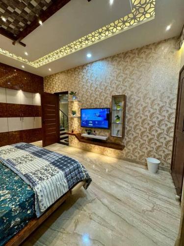 a bedroom with a bed and a flat screen tv at Ultra Luxurious 4 Floor Villa in Bengaluru