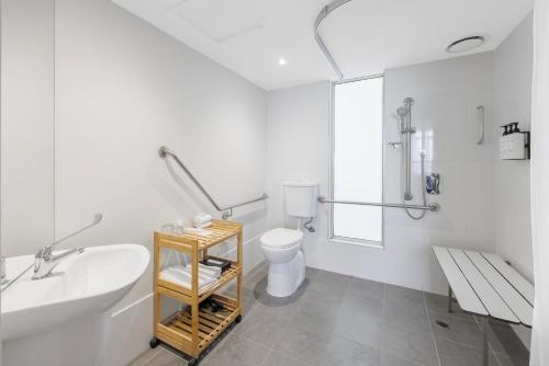 a white bathroom with a sink and a toilet at Quest Caroline Springs in Caroline Springs