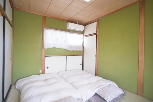 a bed in a room with a window at 一棟貸切AKARIYA Home in Karatsu
