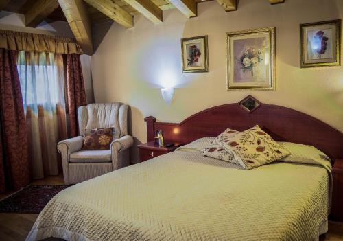 ein Schlafzimmer mit einem großen Bett und einem Stuhl in der Unterkunft Hotel San Paolo in Camposampiero