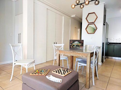 a dining room with a table and a chess board at Brizzy's Garden Luxe Retreat Great Location! in Gqeberha