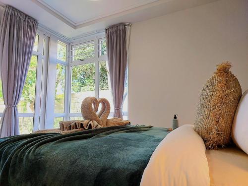 a bedroom with a bed with twoeddy bears on it at Brizzy's Garden Luxe Retreat Great Location! in Gqeberha
