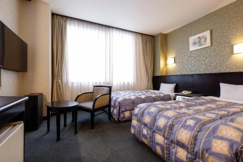 Postel nebo postele na pokoji v ubytování Kotohira Riverside Hotel