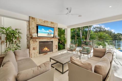 a living room with a couch and a fireplace at Villa 8 The Lakes in Yaroomba