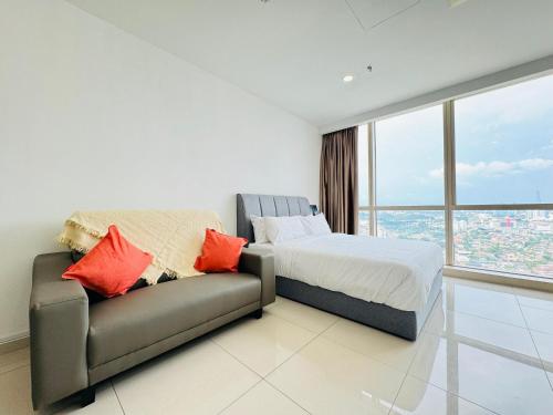 a bedroom with a bed and a couch at Pinnacle Pj by DeUrban in Petaling Jaya