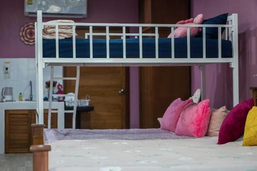 a bedroom with a bunk bed with pink pillows at แอนฟาร์มรีสอร์ทแอนด์คาเฟ่ in Mae Mo