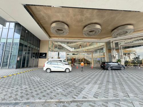 two cars parked in a parking lot in front of a building at Pinnacle Pj by DeUrban in Petaling Jaya