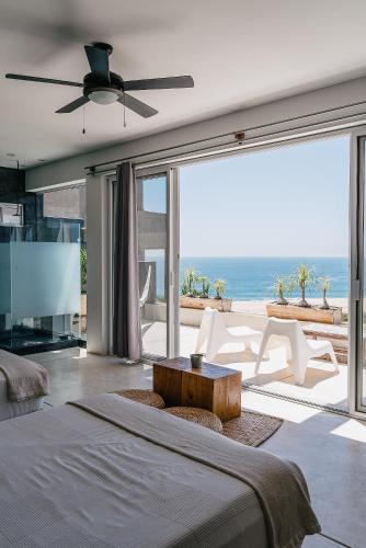 a bedroom with a bed and a view of the ocean at Villas La Mar - Adults 15 plus in Todos Santos