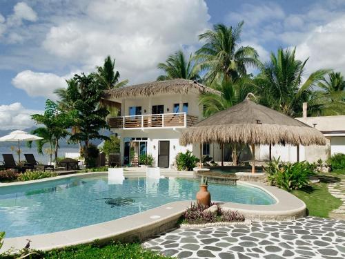 a villa with a swimming pool and a house at Avila's Horizon Dive Resort Santander in Santander