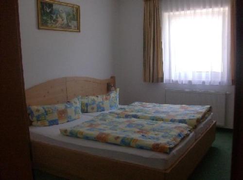 a bed sitting in a bedroom with a window at Appartementhaus Honznhof in Längenfeld