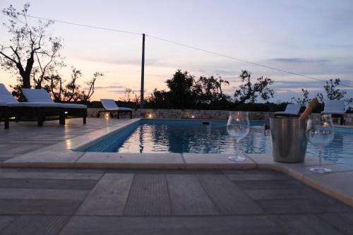 a swimming pool with two wine glasses next to it at Villa Mest Pepp in Monopoli