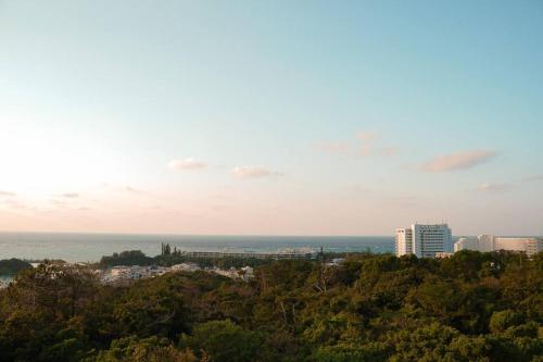 a view of a city with buildings and the ocean at ホテルコンドミニアム土花土花 in Onna