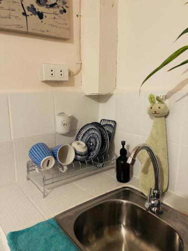 a kitchen sink with a rack with dishes on it at Nordic Style Homestay Davao in Davao City