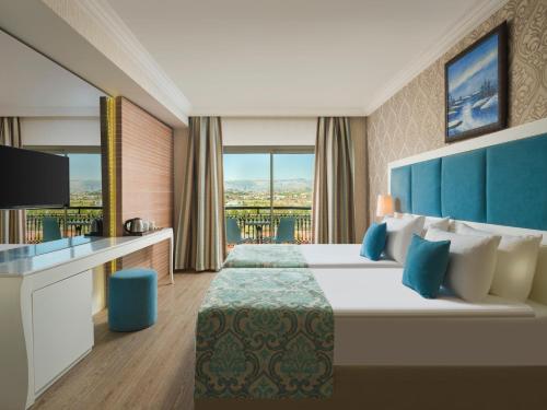 a hotel room with a large bed and a television at Asteria Bloom Side in Kizilagac
