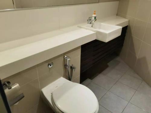 a bathroom with a white toilet and a sink at YOU & ME 118 SWEET HOUSE in Tanjong Tokong