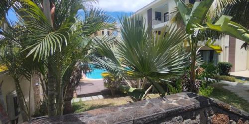 a view of a resort with palm trees and a pool at Anaya Résidence in Flic-en-Flac