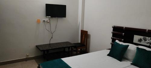 a bedroom with a bed and a tv on the wall at Hotel Holiday in Bharatpur