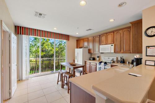 a kitchen with wooden cabinets and a large window at Vista Cay Resort, Next To Universal #821 in Orlando