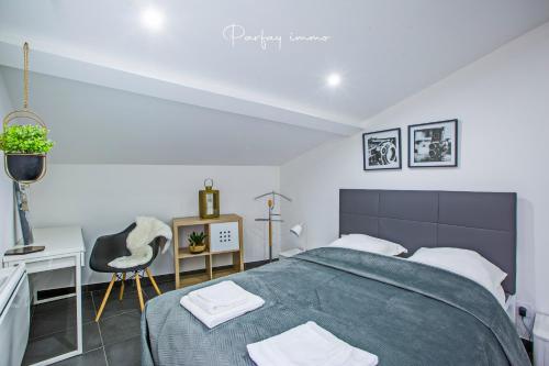 une chambre avec un lit, un bureau et une chaise dans l'établissement Agréable et moderne 2 pièces ~ confort et design, à Clermont-Ferrand