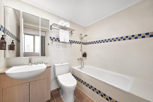 a bathroom with a sink and a toilet and a tub at Somerset Chancellor Court Ho Chi Minh City in Ho Chi Minh City