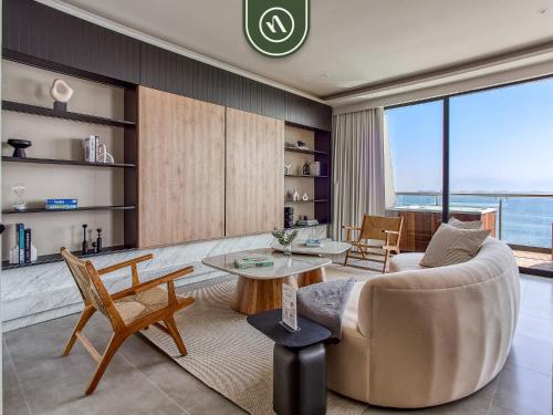 a living room with a couch and a table at Luxury Oceanfront 3 BR Condo - Private Jacuzzi in Cruz de Huanacaxtle