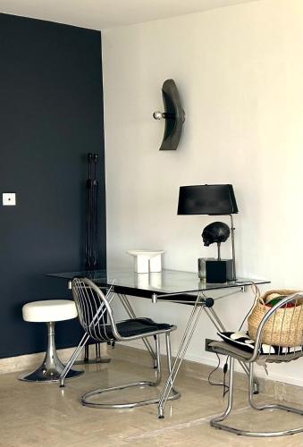 - une table en verre avec des chaises et une lampe dans la chambre dans l'établissement Riviera rooftop - front de mer avec terrasse dans le centre, à Antibes