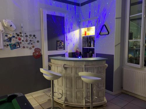 - un bar avec deux tabourets dans une pièce à éclairage violet dans l'établissement Grande chambre familliale pour 4 à 5 personnes, à Chef-Boutonne