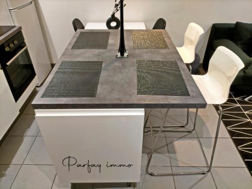 - une table à manger avec un comptoir gris dans l'établissement Le Bogolan ~ Cosy & Design, à Clermont-Ferrand