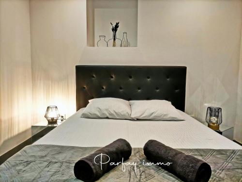 une chambre avec un grand lit avec une tête de lit noire dans l'établissement Le Bogolan ~ Cosy & Design, à Clermont-Ferrand