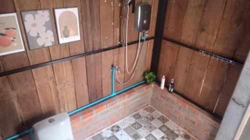 a bathroom with a shower in a wooden wall at Battambang Eco Stay &cooking class in Battambang