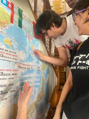 two people looking at a map of the world at Guest House Chara in Hirosaki