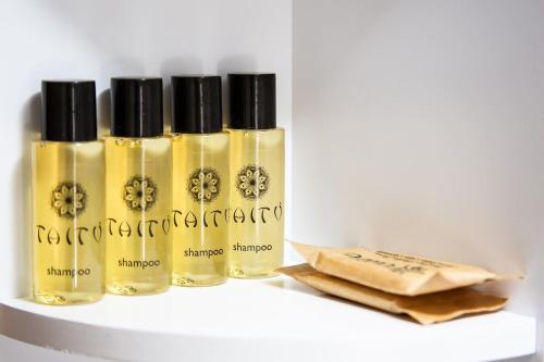 a group of four bottles of oil on a shelf at Casa Liscidini in Aprica