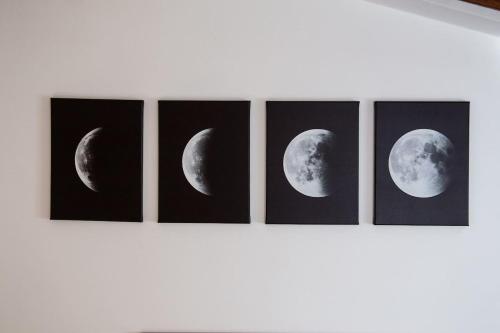 four paintings of phases of the moon on a wall at Casa Liscidini in Aprica