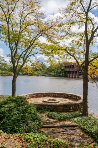 a stone circle in the middle of a river with trees at Hyatt Lodge Oak Brook Chicago in Oak Brook