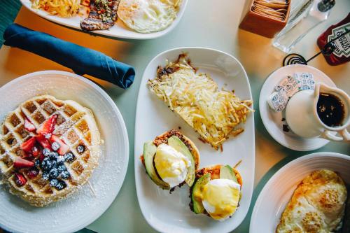 a table topped with plates of breakfast foods and coffee at Hyatt Lodge Oak Brook Chicago in Oak Brook