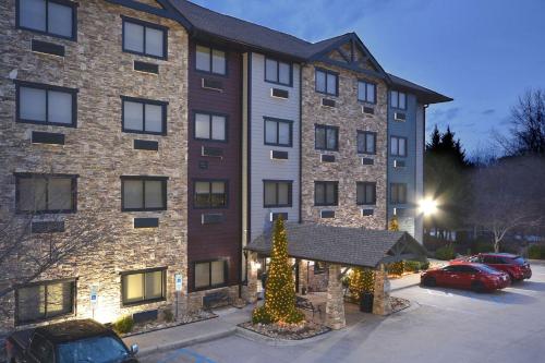 a large brick building with christmas lights in a parking lot at Brookstone Lodge near Biltmore Village, an Ascend Collection Hotel in Asheville