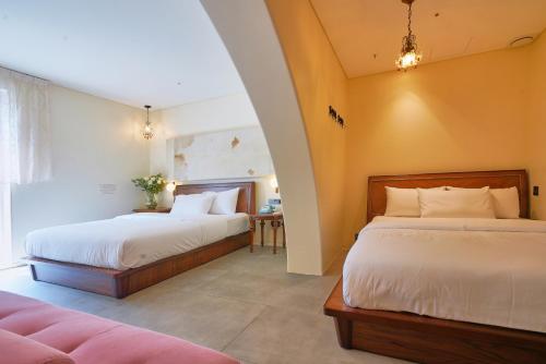 首尔Hotel Lemong的有两张床和一张桌子的卧室