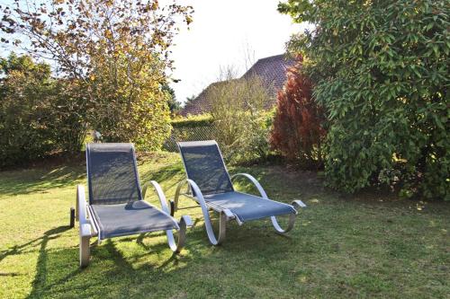 two chairs sitting in the grass in a yard at Ferienhaus Ostseerausch in Scharbeutz