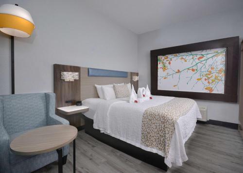 a hotel room with a bed and a chair at Brookstone Lodge near Biltmore Village, an Ascend Collection Hotel in Asheville