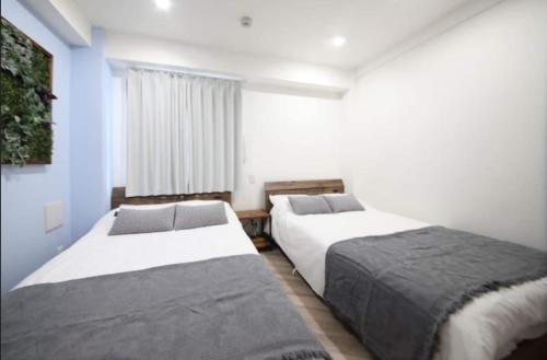 東京にあるShibuya WAVE401 SW41の青い壁の部屋にベッドが2つある