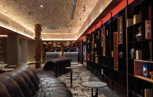 a bar with leather couches and racks of books at Bintang Collectionz Hotel in Kuala Lumpur