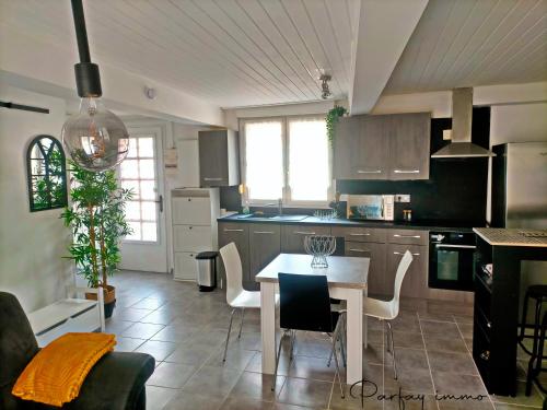 une cuisine avec une table et des chaises dans une pièce dans l'établissement Maison de bourg avec terrasse, à Gerzat