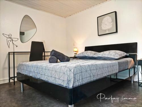 una camera da letto con un letto con uno specchio sul muro di Maison de bourg avec terrasse a Gerzat