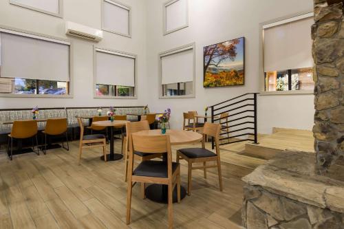 a restaurant with tables and chairs and windows at Graystone Lodge, an Ascend Collection Hotel in Boone