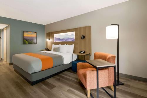 a hotel room with a bed and a chair at Graystone Lodge, an Ascend Collection Hotel in Boone