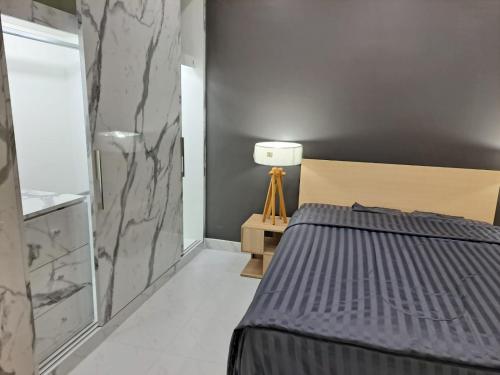 a bedroom with a bed and a marble wall at Modern 2 bedroom & Kitchen - Prime Sukhumvit - BTS MQuartier Phrom Phong in Bangkok