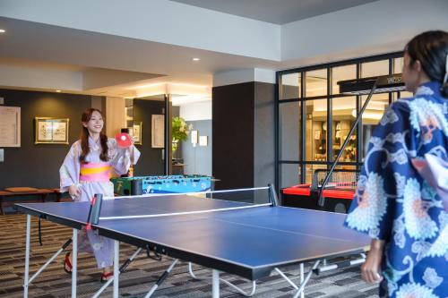 two women playing ping pong in a ping pong table at Hita Onsen Kizantei Hotel in Hita