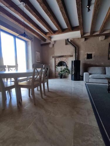 une salle à manger avec une table et des chaises et une cheminée dans l'établissement Maison de campagne, à Villerbon