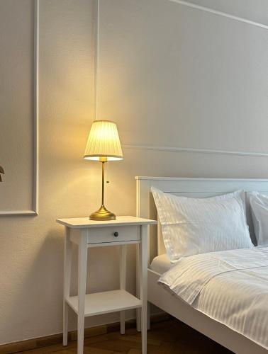 Una cama con una mesa con una lámpara. en Schiller Studio, en Sibiu